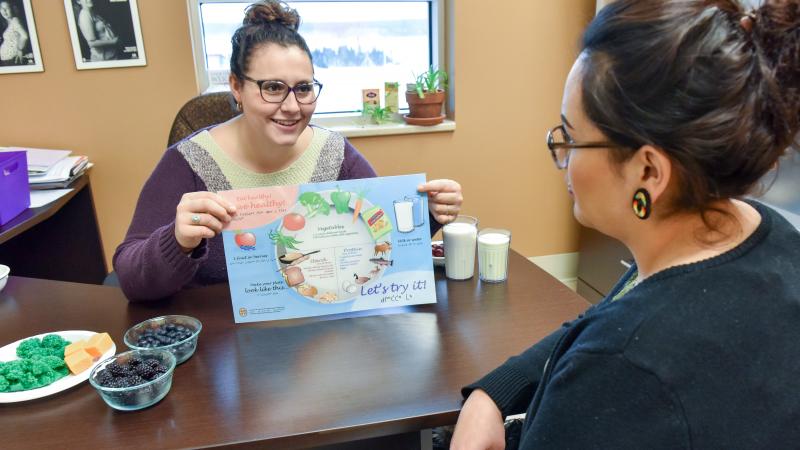 Nutritionist showing client Cree healthy placemat 
