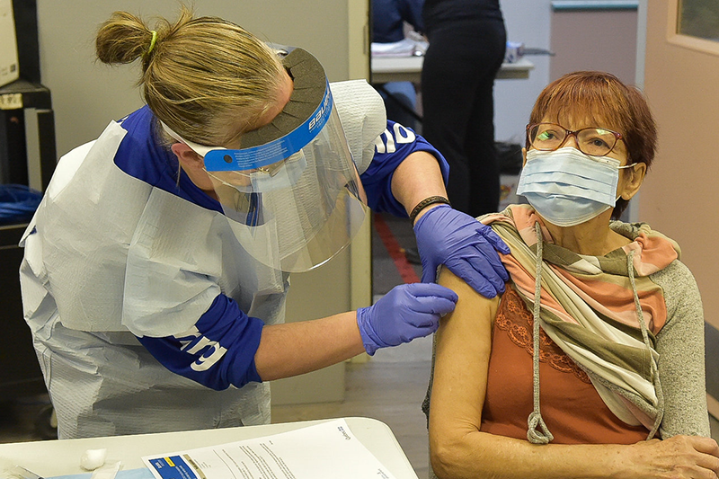 Nurse giving vaccination to elder