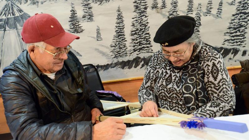 2 elders making snowshoe together