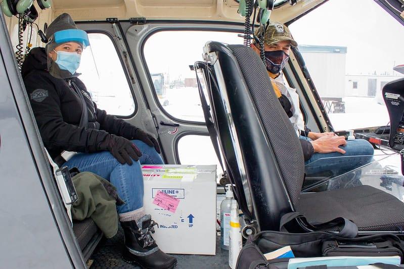 Guylaine Boula and Jason Coonishish on helicopter with box of vaccines