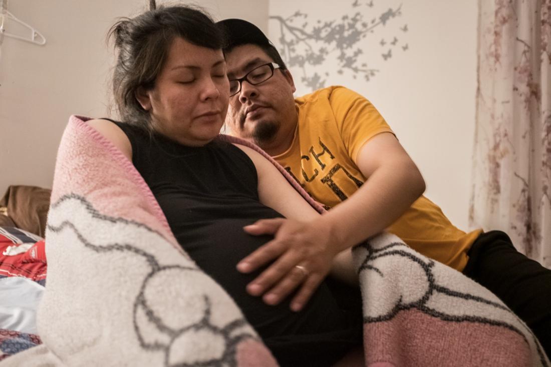 Man comforts pregnant woman who is in labour