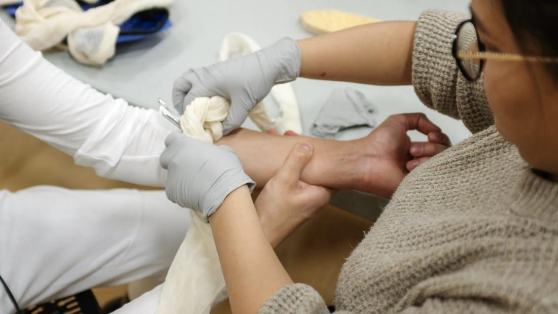 Woman applies bandage 