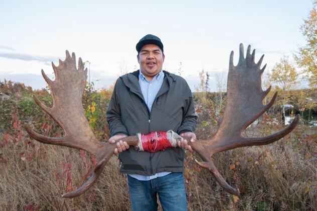 Man stands with moose antlers