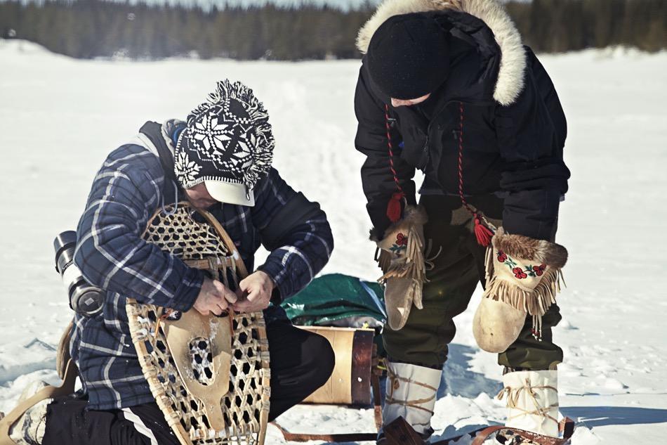 Man shows Cree-style snowshoes to another man