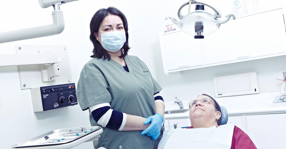 Dental hygienist standing next to patient