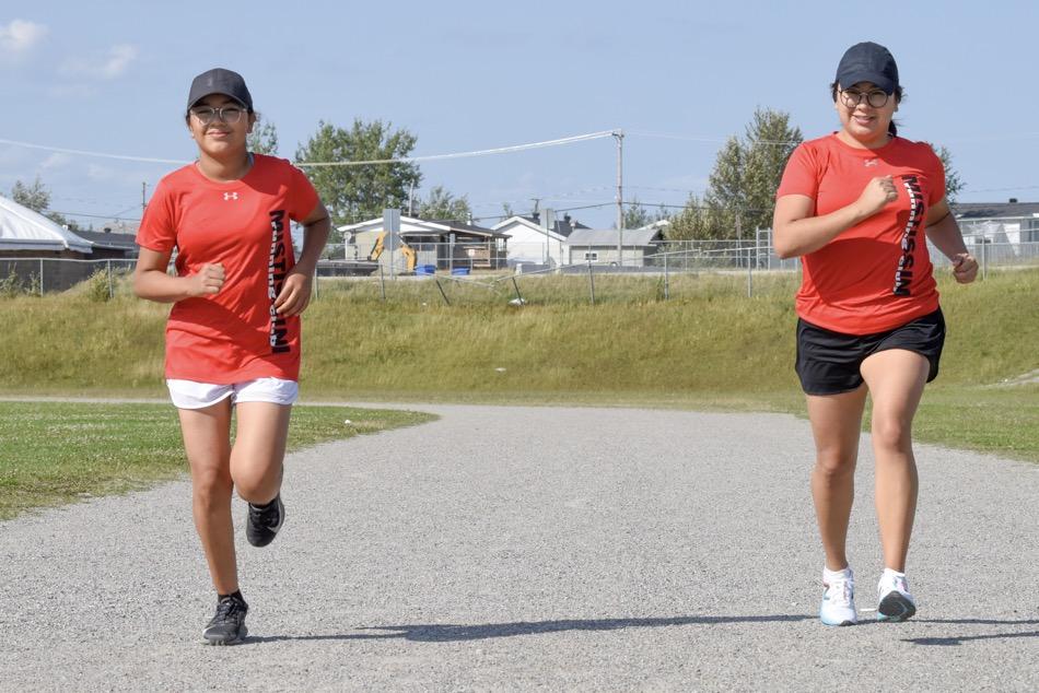 Mother and daughter running on sports track
