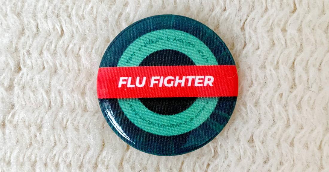 Photo of pin that says flu fighter on it to encourage people to get their flu vaccine this season
