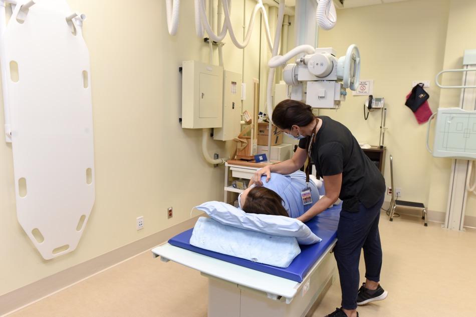Medical imaging technician turns patient onto her side