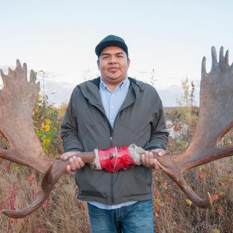 Man holding moose antlers 
