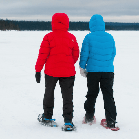 2 women snowshoeing across frozen lake