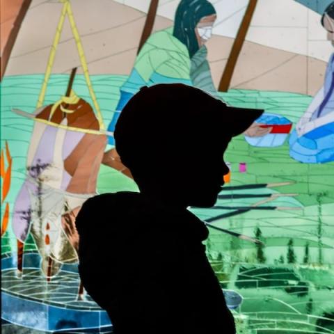 Silhouette of child against community mural