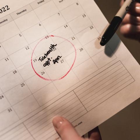 Paper calendar with health appointment marked in black ink with red circle